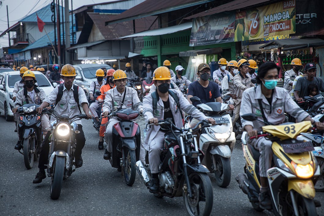 Arbetare i Indonesien på mopeder.