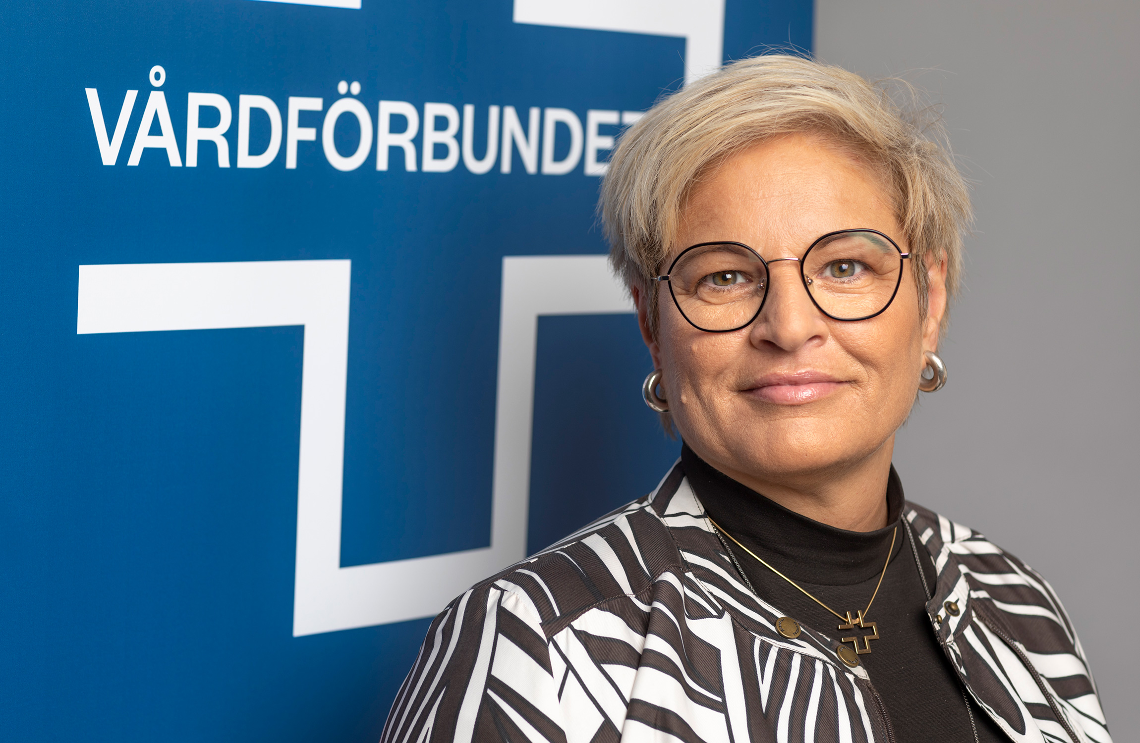 Sineva Ribeiro, förbundsordförande i Vårdförbundet. Här framför en logga för fackförbundet.