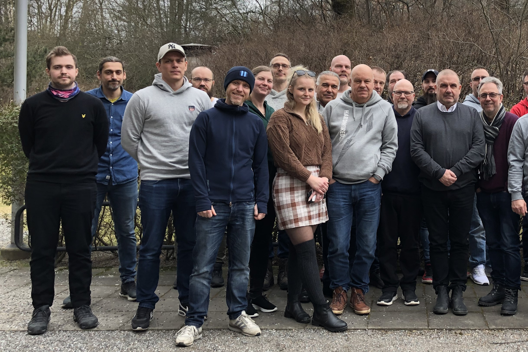 En grupp på flera personer står utomhus och tittar mot kameran.