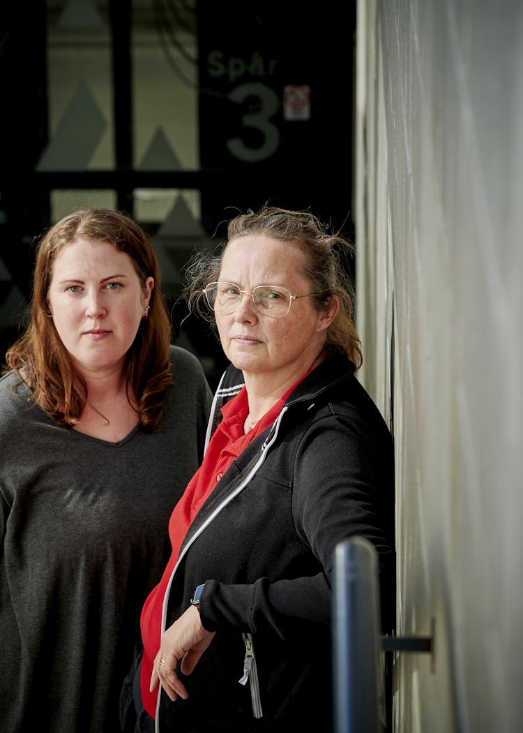Två kvinnor står vid en byggnadsingång.