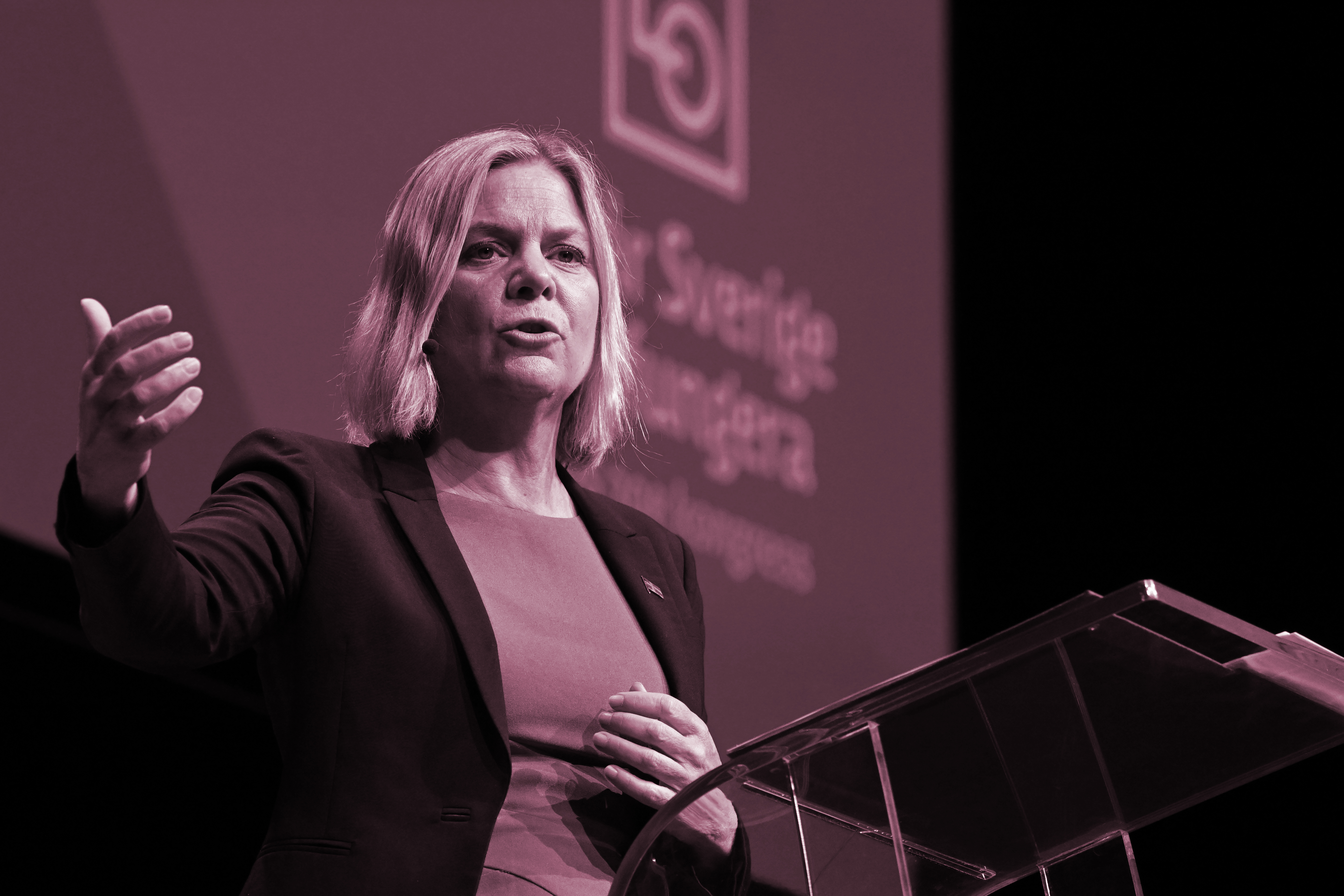 En kvinna står på scen i rött filter.