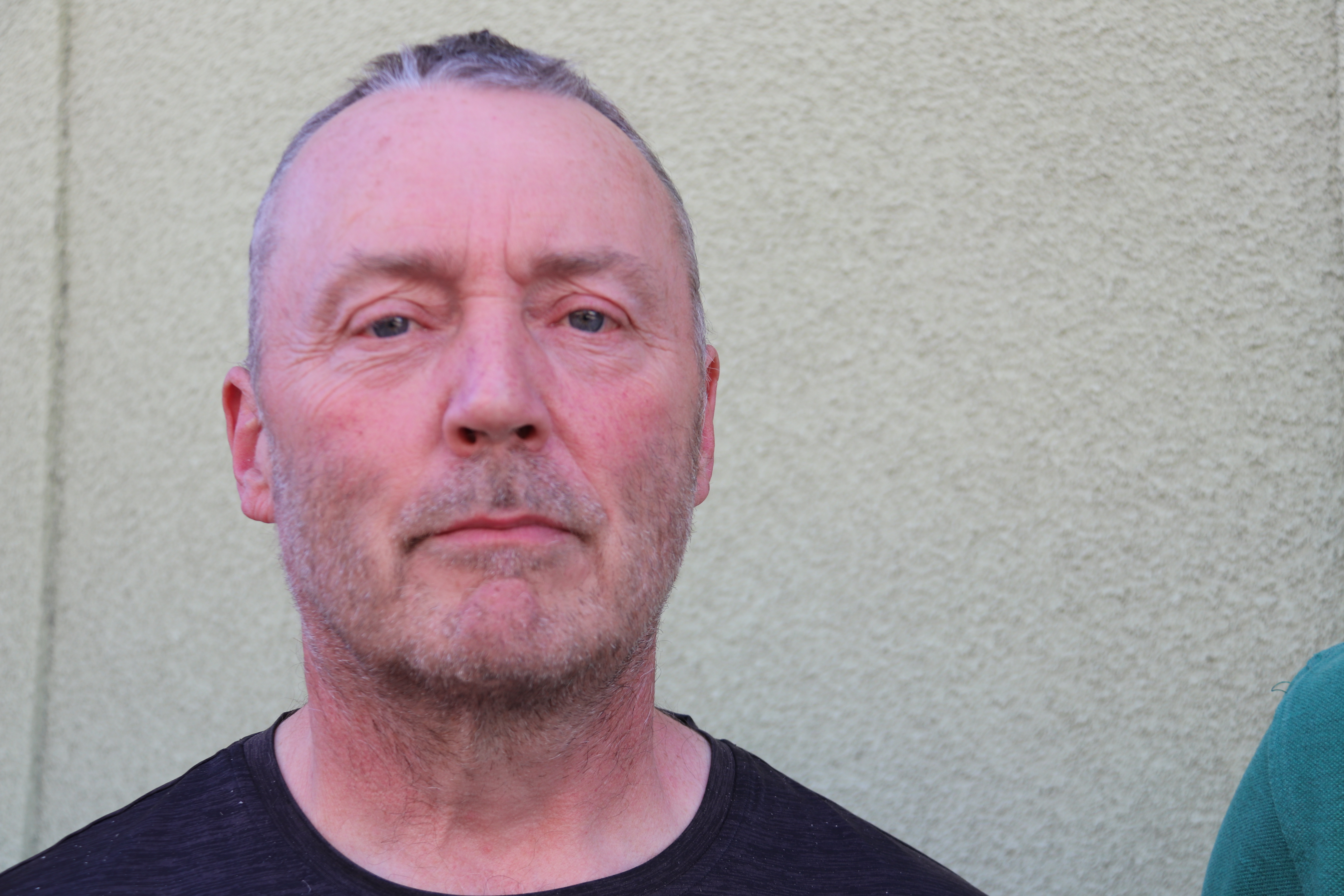 Man i svart tröja tittar i kameran.