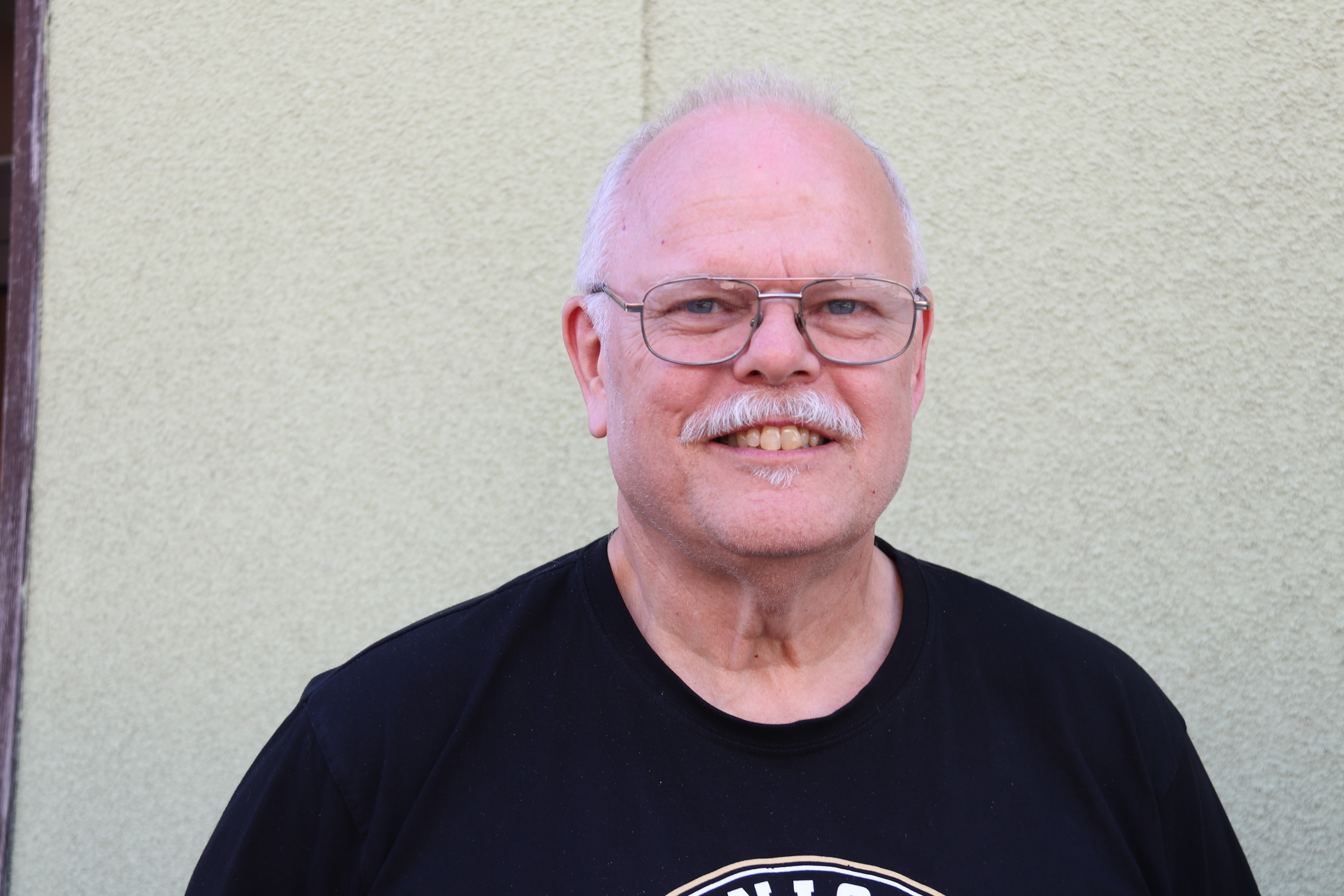 Man i svart tröja titta i kameran.