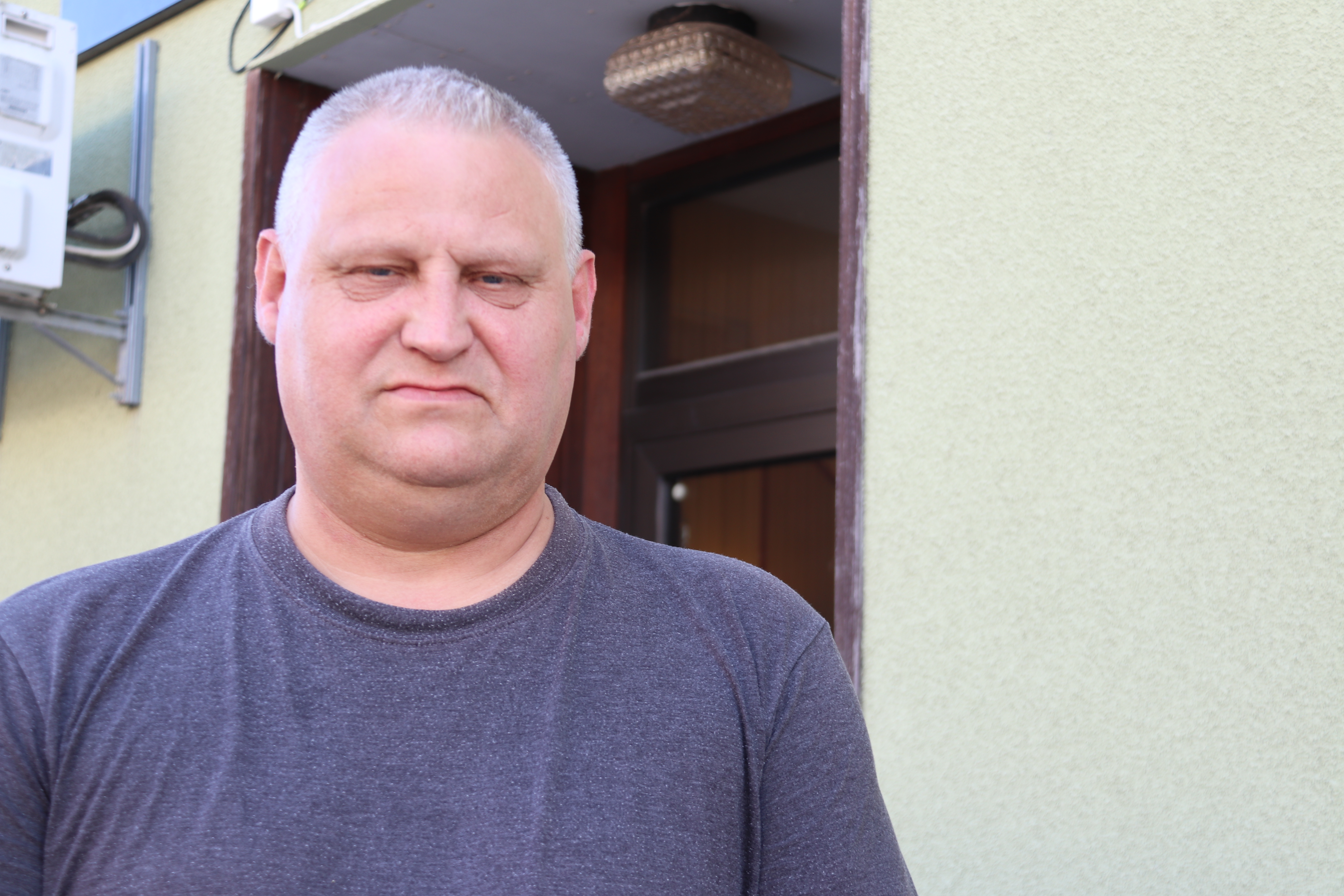 Man i blå tröja tittar i kameran.