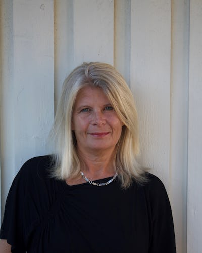 Kvinna framför vit vägg