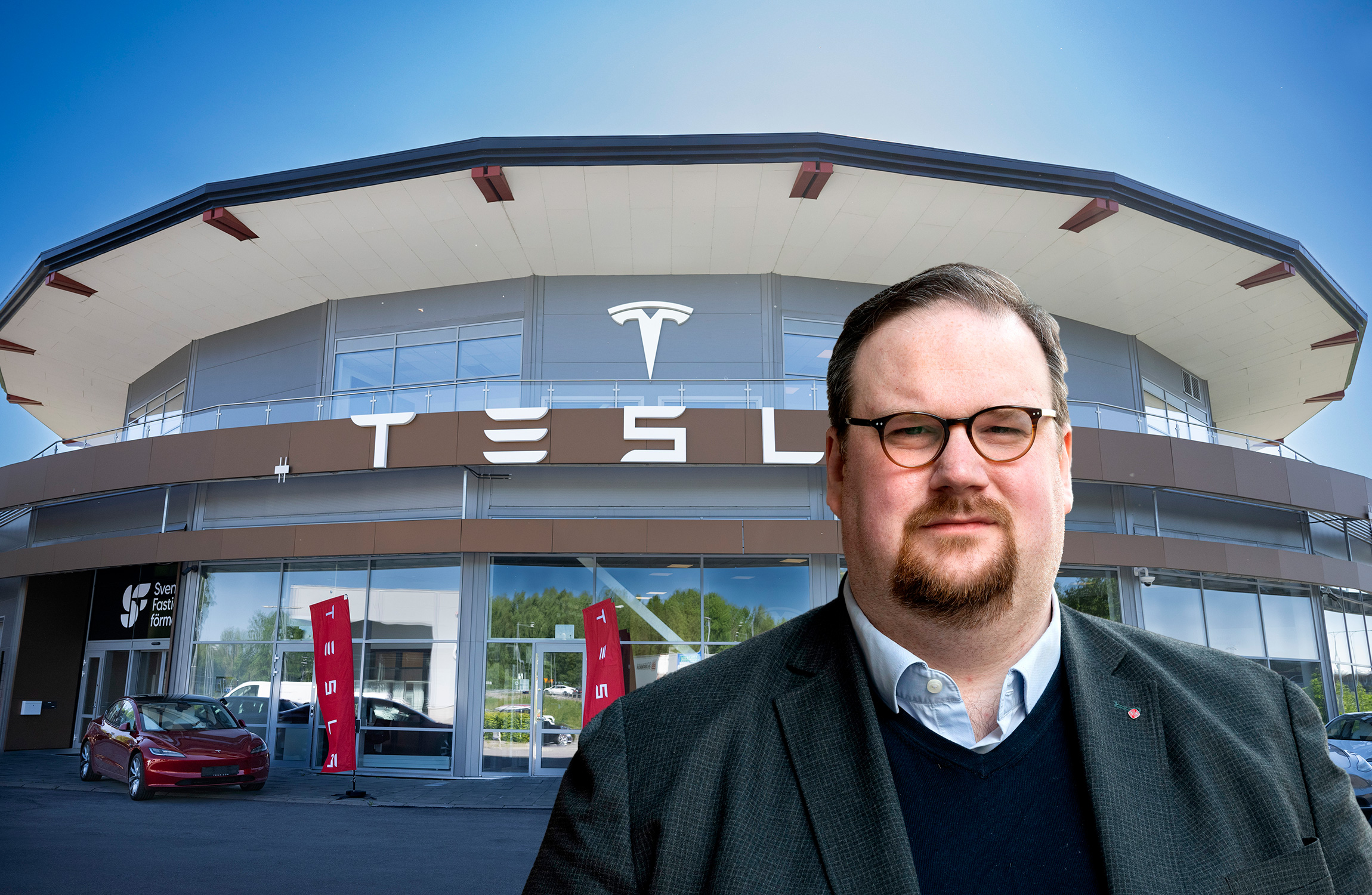En person i affärskläder står framför en Tesla-butik på en soldag.