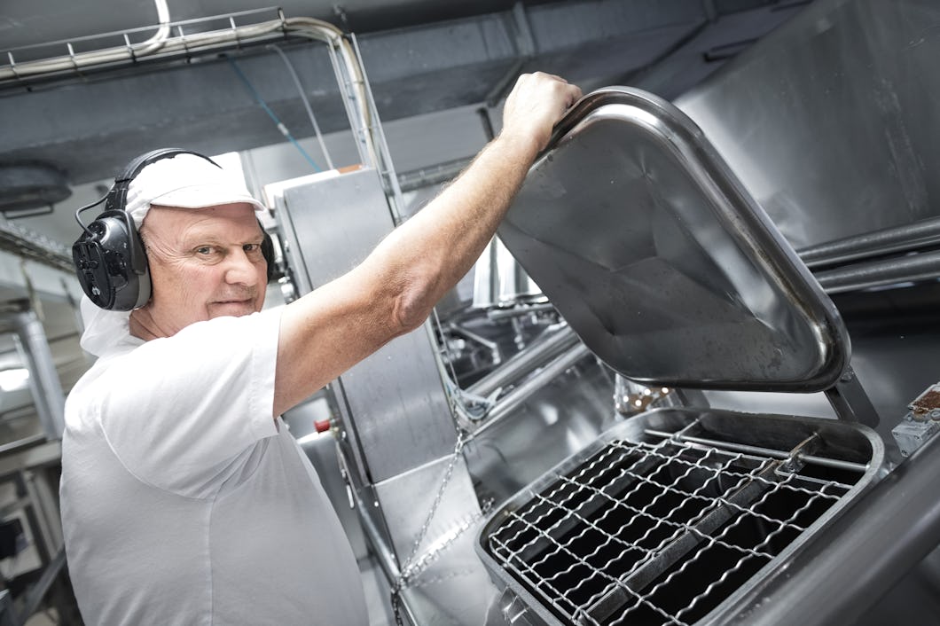 Magnus Hedå lyfter ett stort metallock.