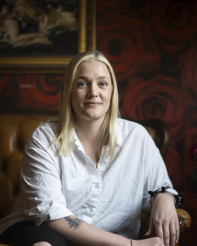 En person sitter på en läderstol och poserar för kameran.