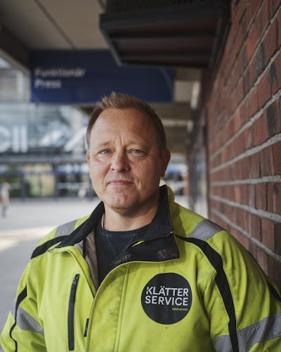 Porträtt på Johan Lernell utomhus bredvid en tegelvägg.