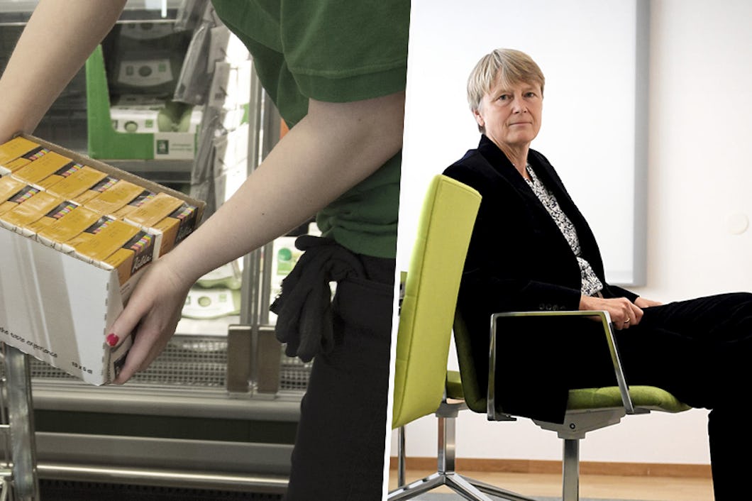 En person i grön skjorta lyfter en låda med förpackade varor från en vagn. En annan person i svart jacka sitter på en stol mot en enkel bakgrund.