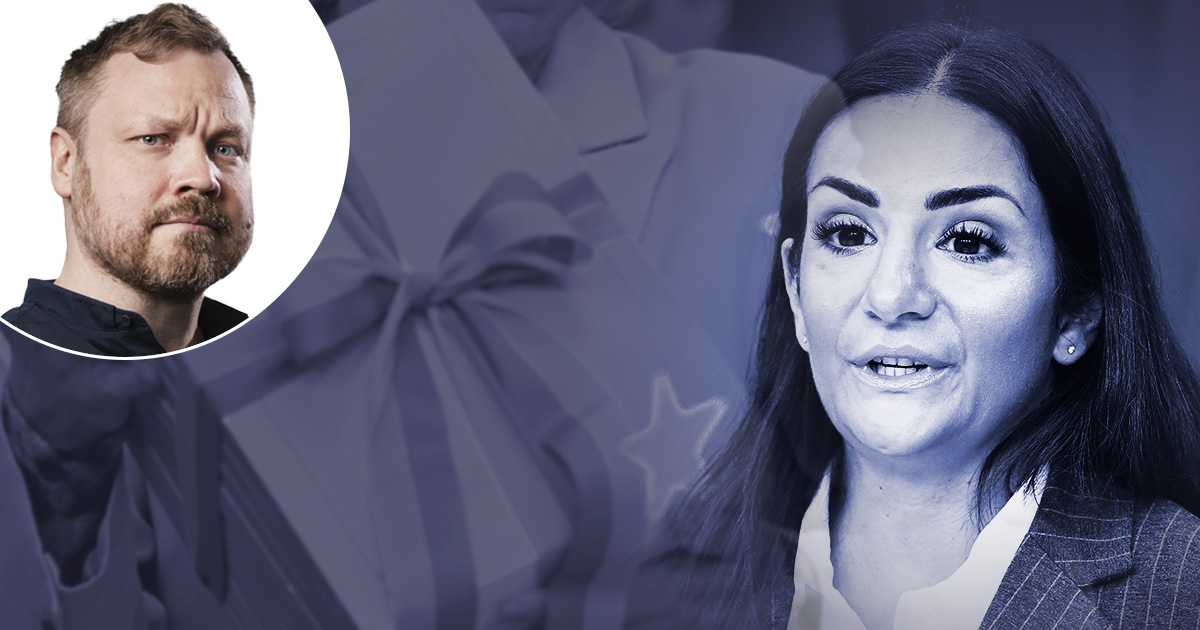 Parisa Liljestrand som talar, med en oskarp bakgrund där ett bandförsett paket och stjärnmönster.