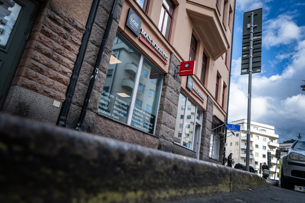 Gatuvy av en flervåningsbyggnad med en butik som visar kontorsutrustning på bottenvåningen.