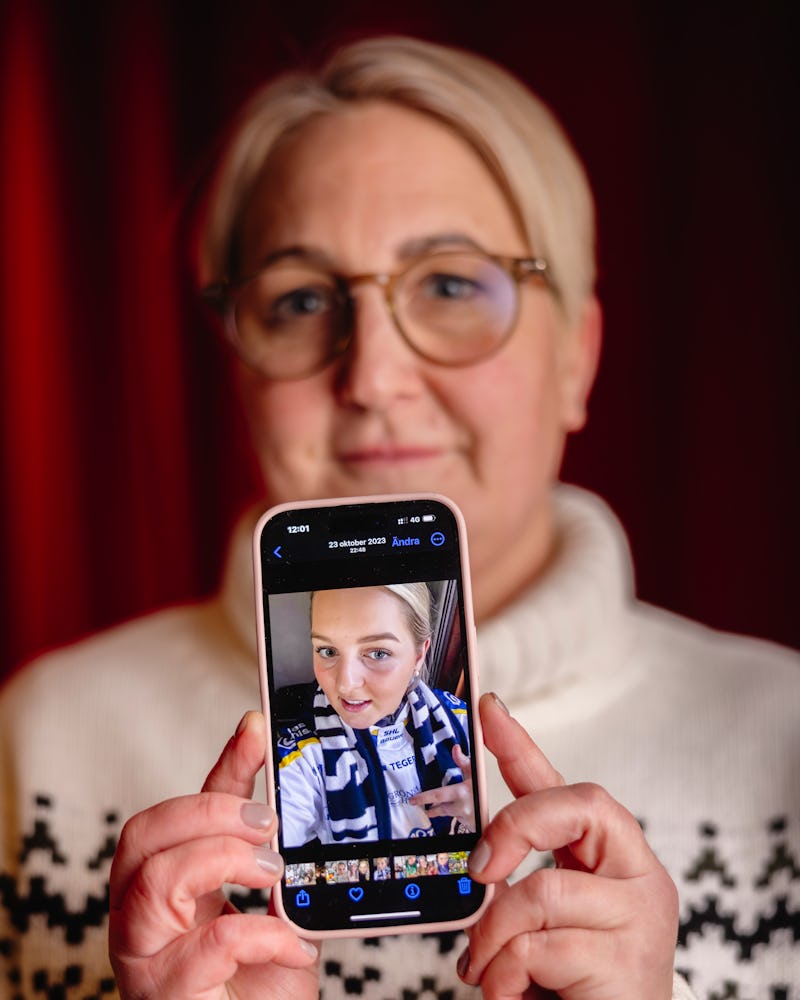 Person med glasögon håller i en smartphone som visar en selfie av dem själva i sportkläder.