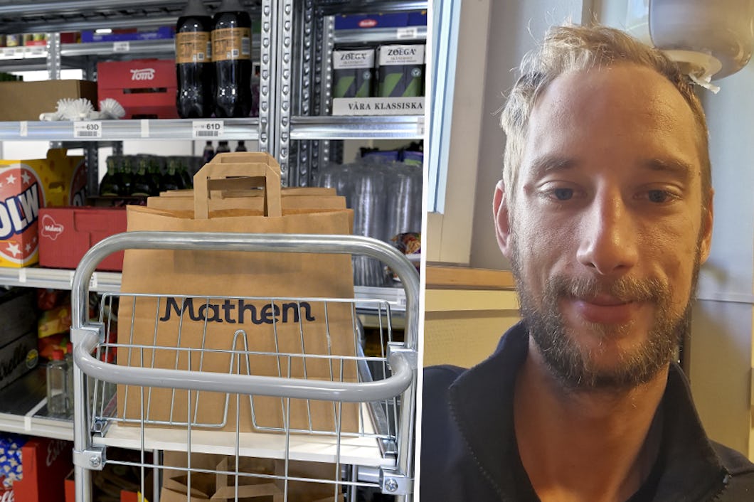 En man står bredvid hyllor fyllda med olika livsmedel som drycker, snacks och andra varor.