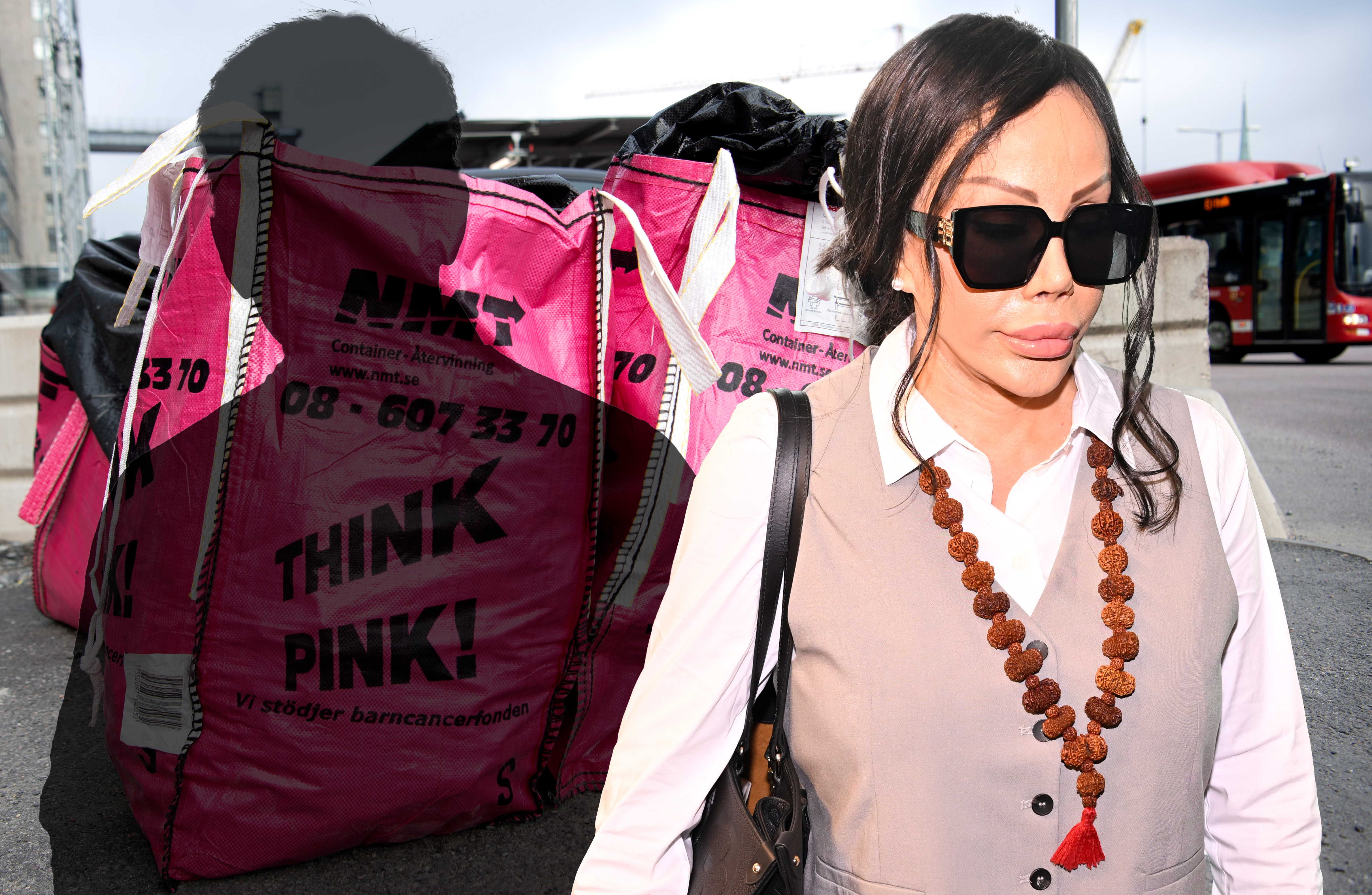 En person med solglasögon och ett pärlhalsband går förbi rosa påsar med texten "Think Pink!" i en stadsmiljö. En röd buss syns i bakgrunden.