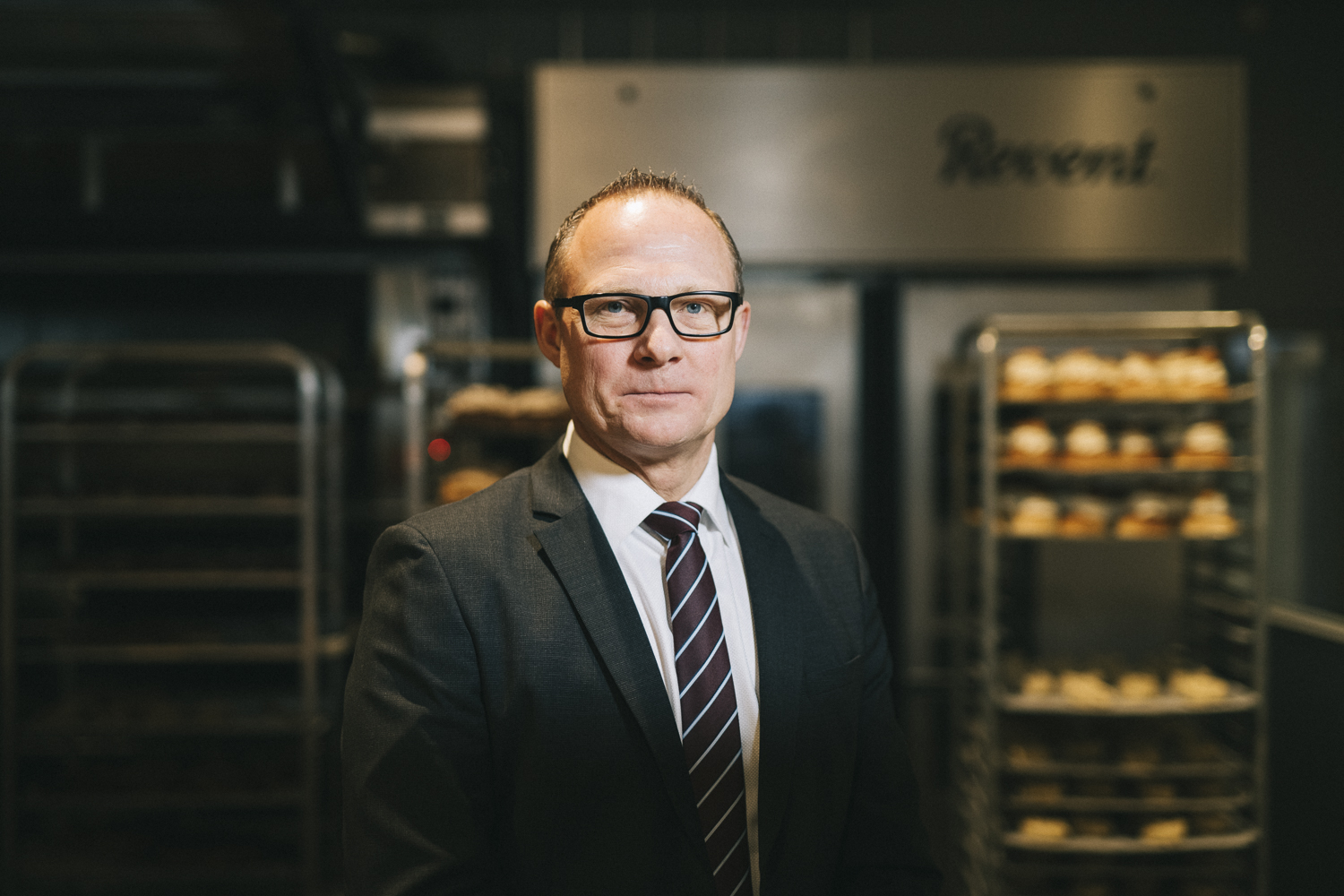 Björn Hellman står i en mörk miljö med något som ser ut som bakplåtar i bakgrunden.