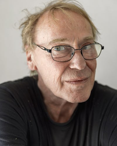 Göran Norr med glasögon och rufsigt hår ser rakt mot kameran. Han bär en svart skjorta och står framför en enkel bakgrund.