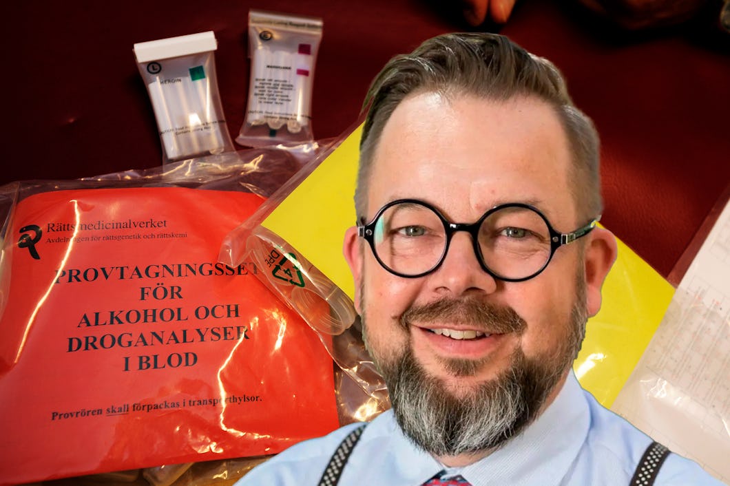En person med glasögon och skägg står framför ett blodanalyskit. I bakgrunden syns märkta påsar och provrör.