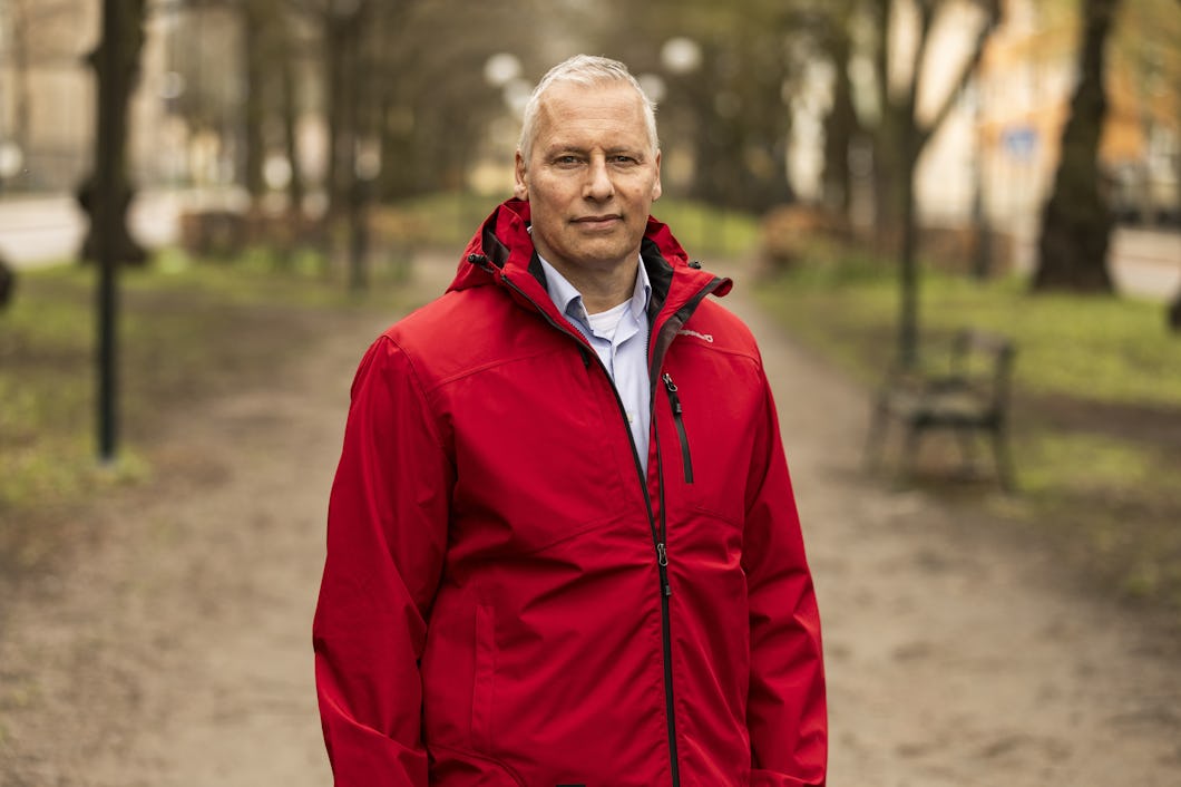 Porträtt på Jimmy Johansson som står utomhus i röd jacka.