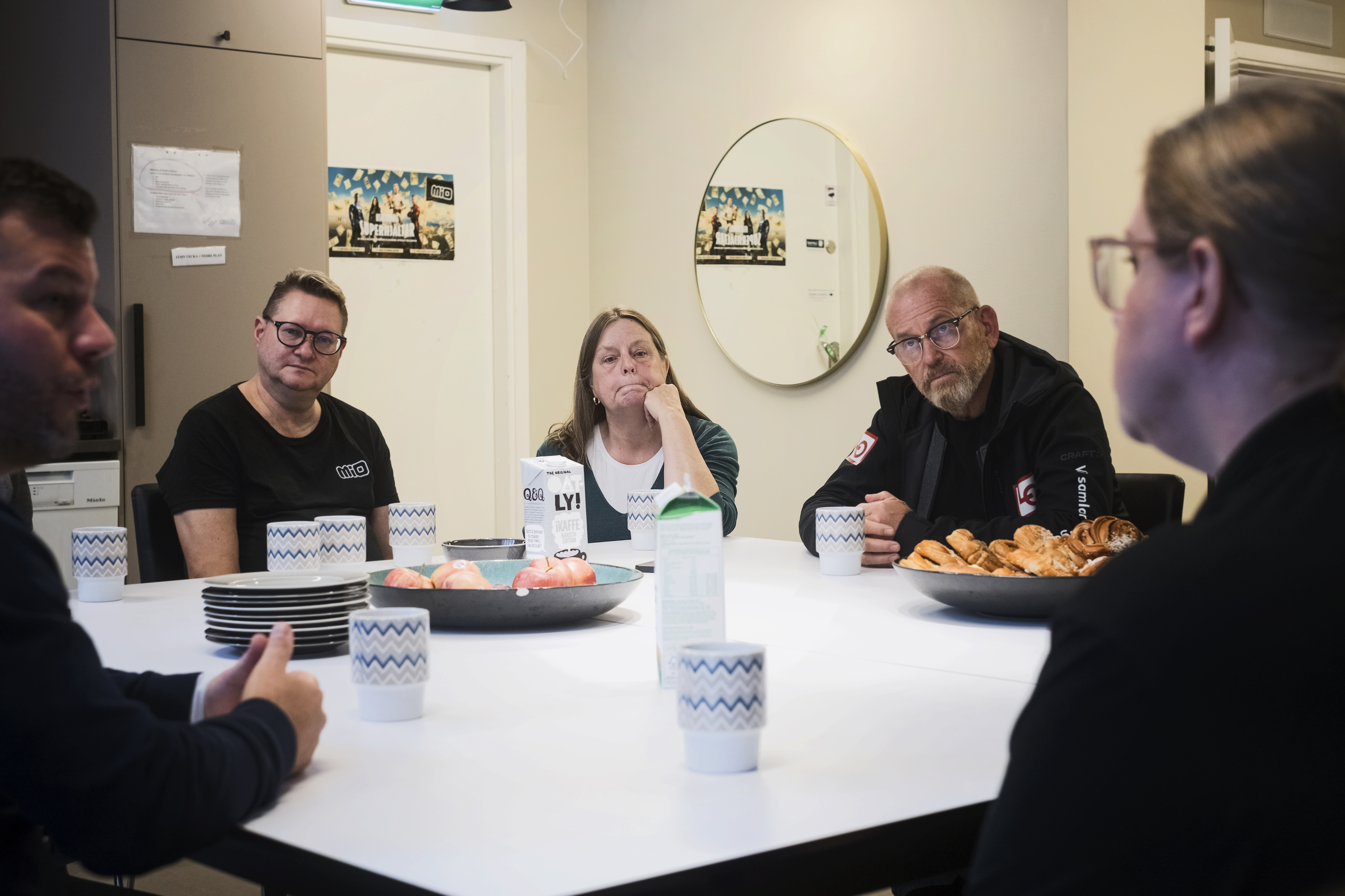 En grupp personer sitter vid ett bord och samtalar.
