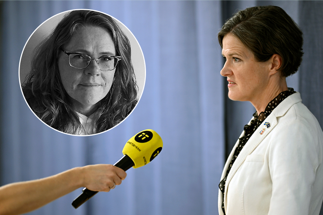 Anna Kindber Batra i vit kostym talar i en mikrofon som hålls av någon annan. I nedre hörnet finns en cirkel med bilden av ytterligare en person.