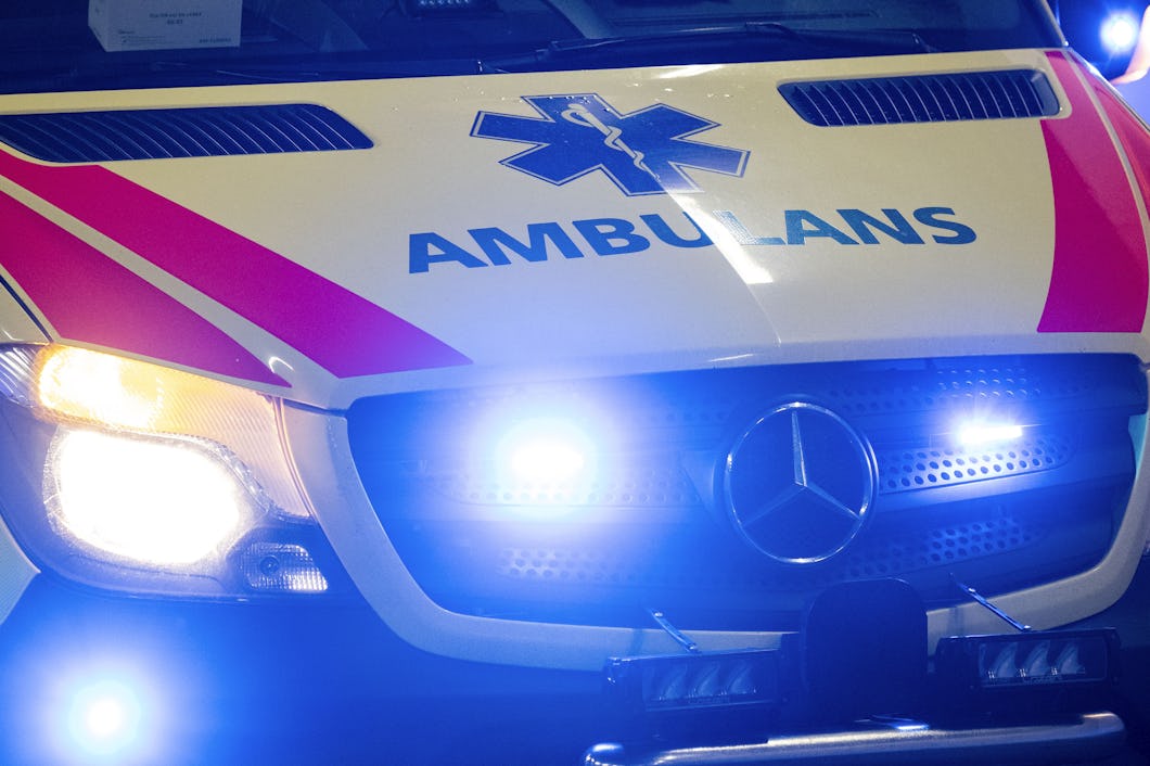 Närbild på ambulans med texten ”AMBULANS” på motorhuven.