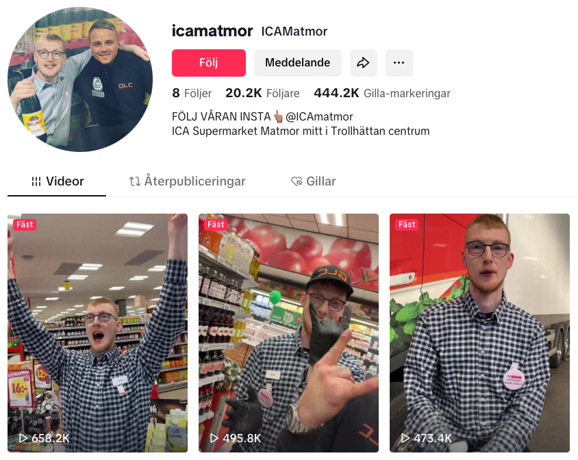 En man i en rutig skjorta står i en mataffär och håller troféer på två foton.