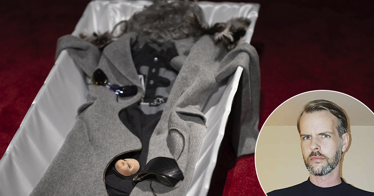 Bildens alt-text kan vara: "En kista innehåller en grå kappa med svarta tillbehör och ett dockhuvud. I hörnet visa en infälld bild på en man med skägg och kort hår.