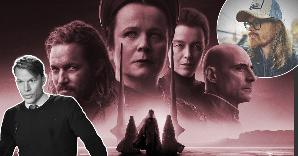 En grupp skådespelare i mörka kostymer framför en stor bakgrund.