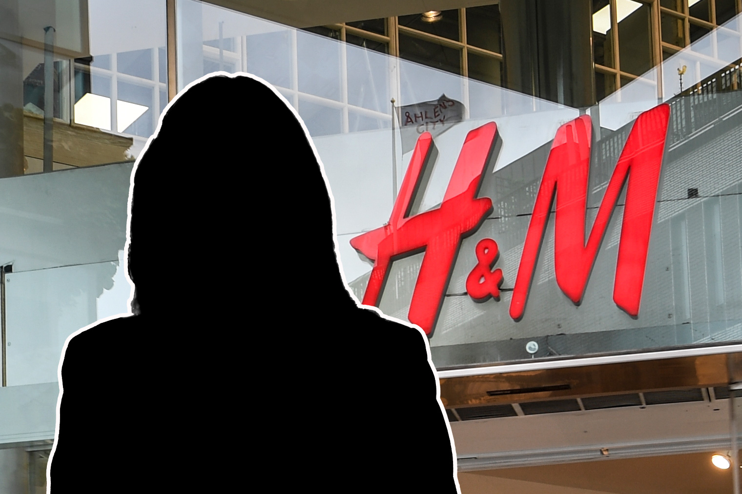 En persons silhuett vid ingången till en H&M-butik.