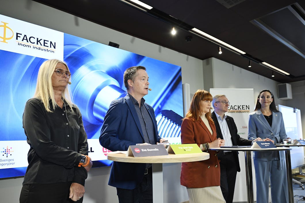 Fem personer står framför en stor skärm som visar grafik med loggan för Facken inom industrin.