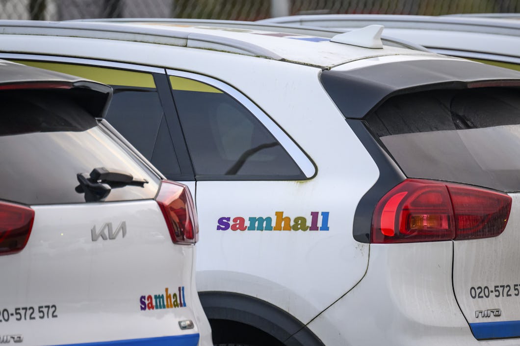 Tre fordon med "samhall"-logotyper är parkerade bredvid varandra på en parkering.