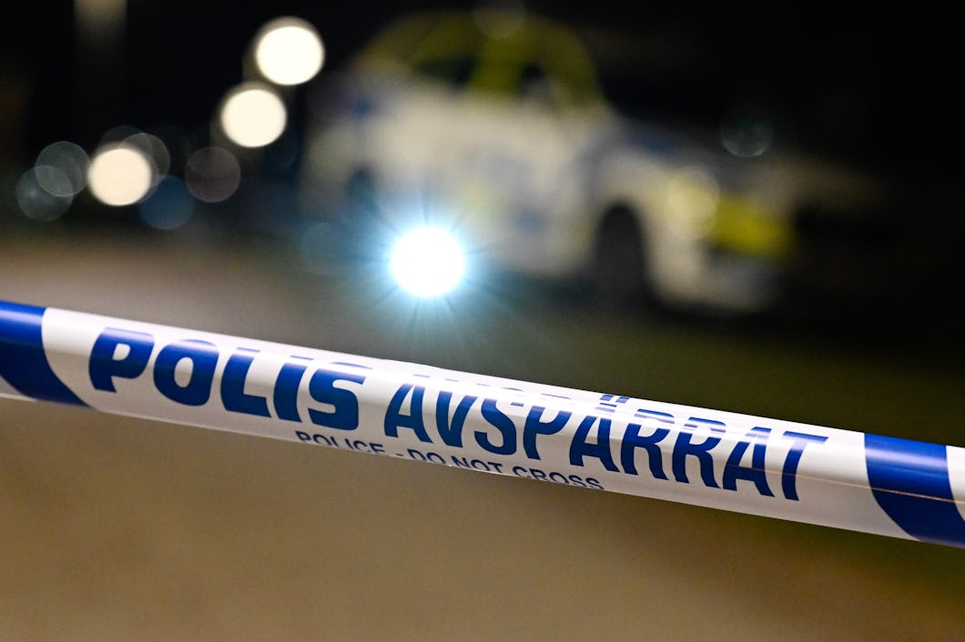 Polisavspärrning med bil i bakgrunden.