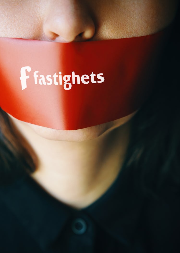 En person med rakt mörkt hår har en bit röd tejp över munnen med texten "Fastighets", vilket antyder censur eller tystnad.