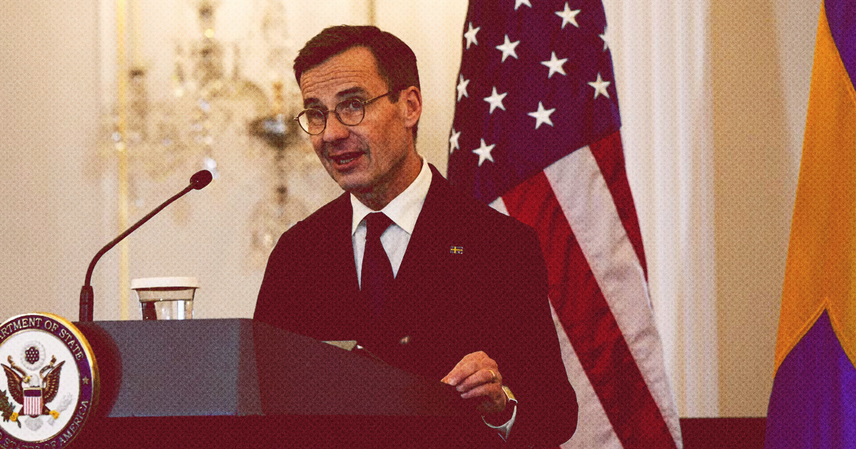 Ulf Kristersson, framför amerikanskt podium med svenska flaggan och amerikansk flagga i bakgrunden.