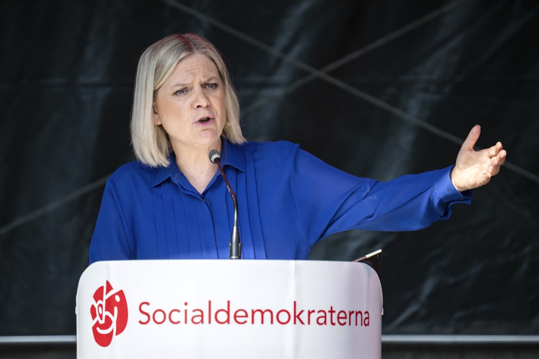 Socialdemokraternas partiledare Magdalena Andersson står på ett podium med Socialdemokraternas logga på.