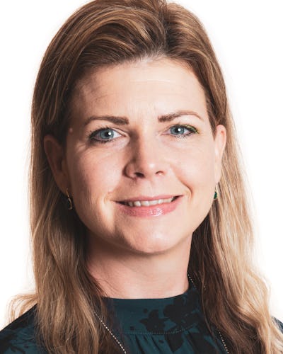 Sofia Jarl med ljust brunt hår och blå ögon ler mot kameran. Hon har på sig en mörk överdel och små ringformade örhängen. Bakgrunden är vit.