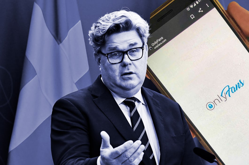 En man i kostym talar vid en talarstol med flaggor bakom sig. Bredvid honom är en smartphone med OnlyFans-appen synlig.