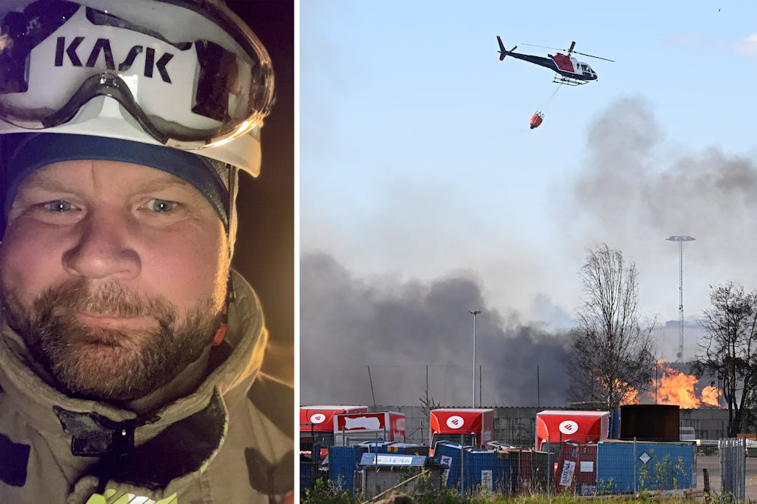 En brandman med utrustning står till vänster, och till högre släpper en helikopter vatten på en eld där rök stiger från ett industriområde.