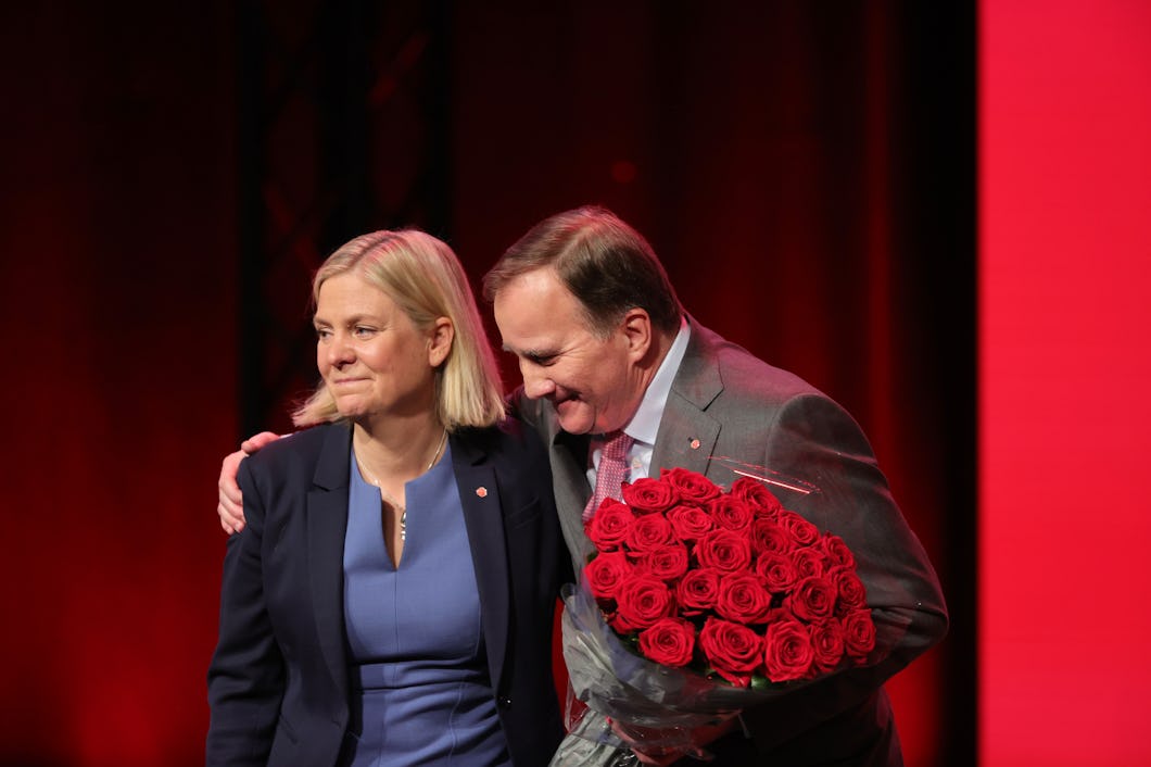 En kvinna och en man står med röda rosor på en scen.