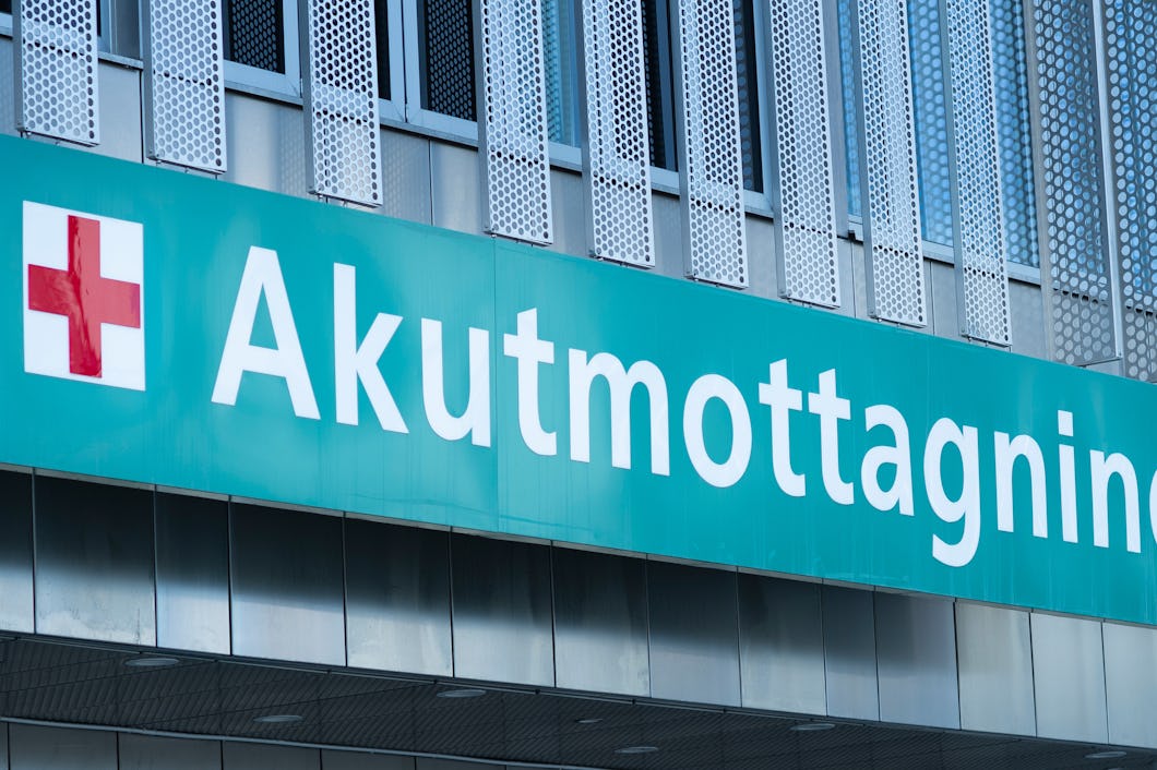 En skylt med ett rött kors och texten "Akutmottagning" visar ingången till akutmottagningen.