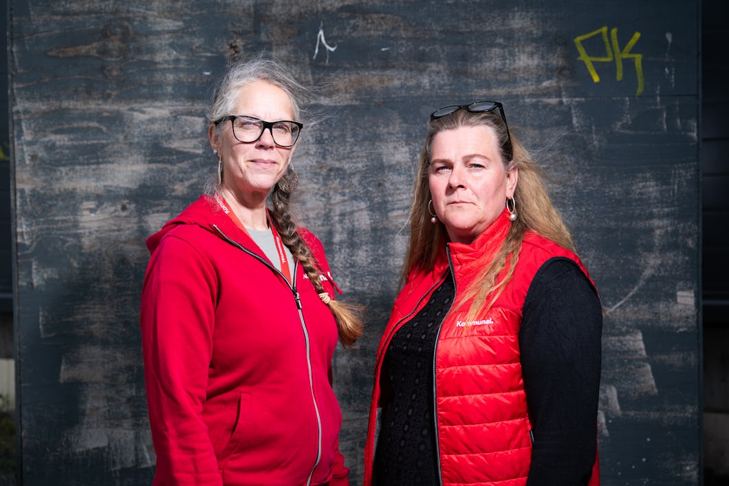 Cecilia Holm och Annie Lisstrand står bredvid varandra framför en vägg med graffiti. Båda har röda ytterkläder.