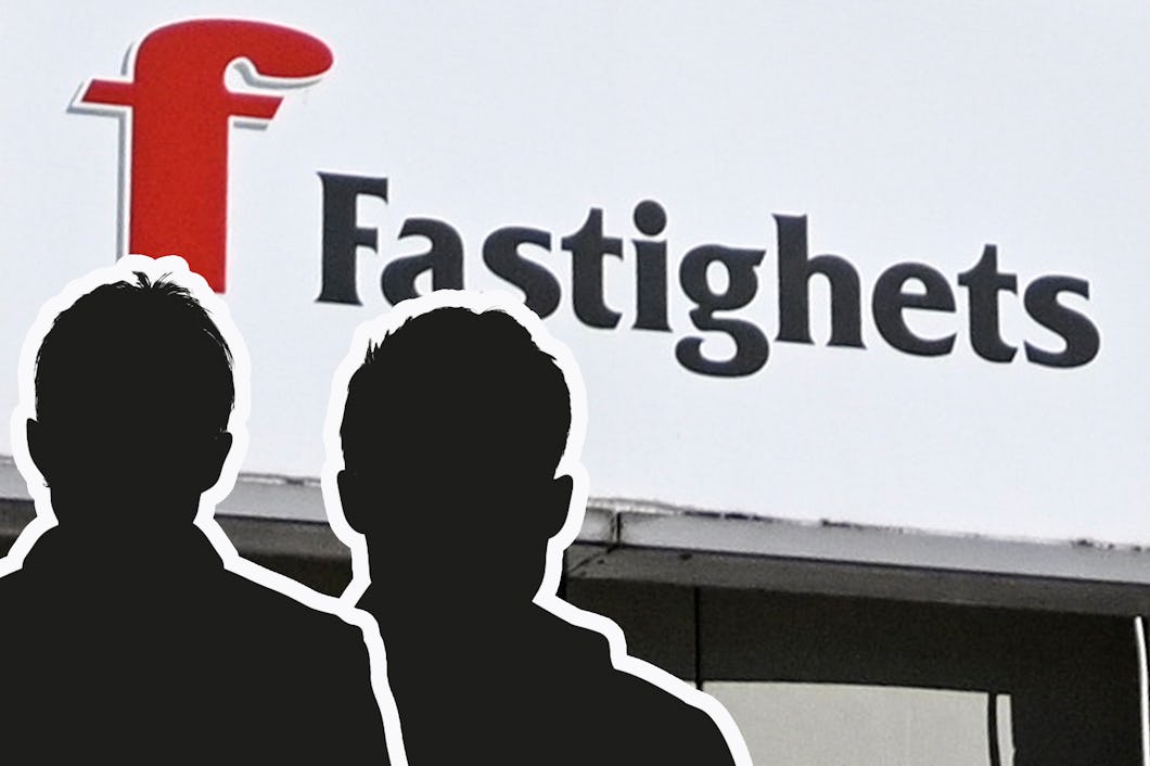 Två personer står framför en byggnad med en skylt där det står “Fastighets”.