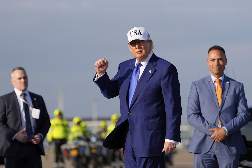 En man med blå kostym och en vit hatt med texten "USA" lyfter sin knytnäve.