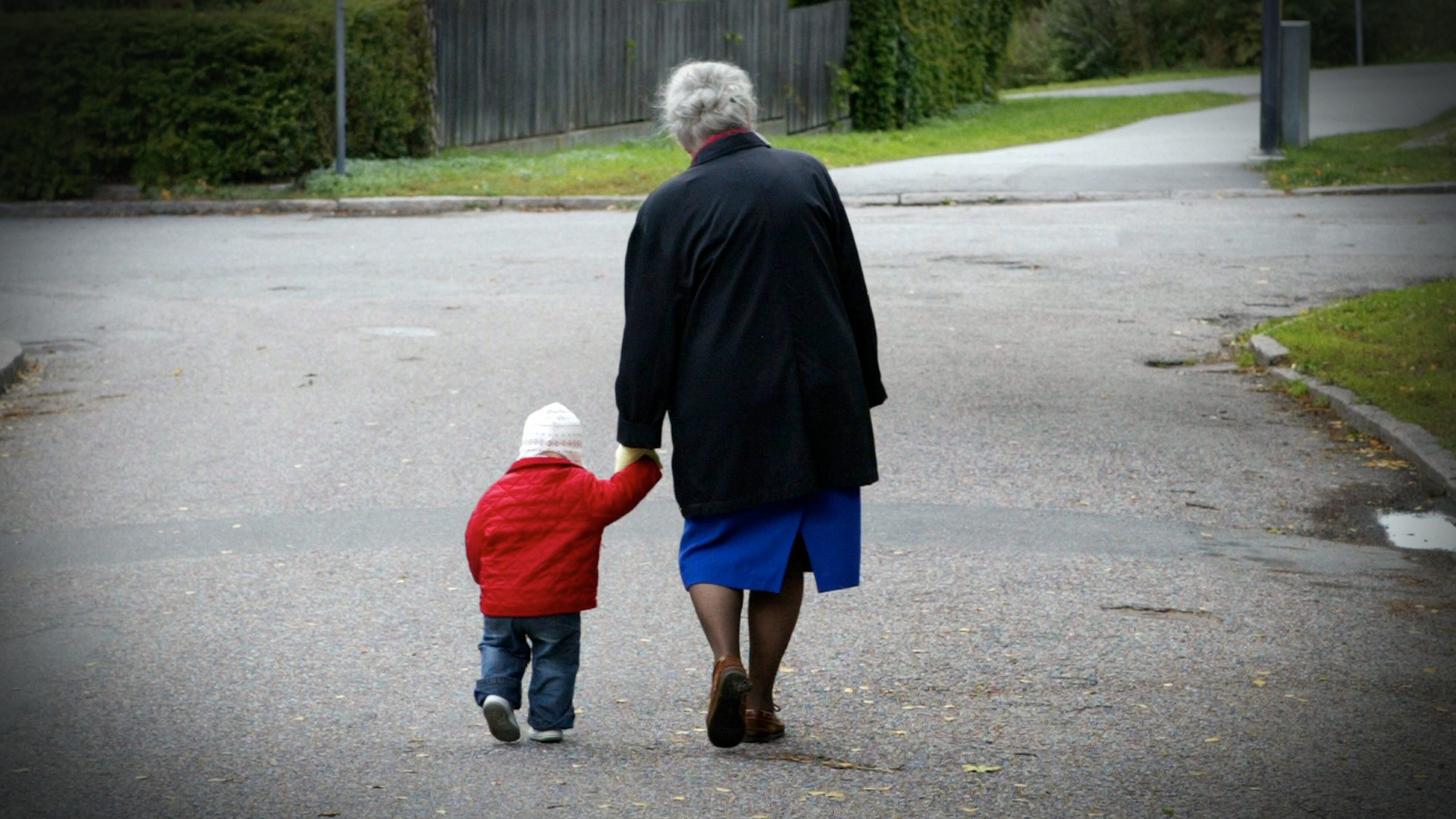 Äldre kvinna går med barn.