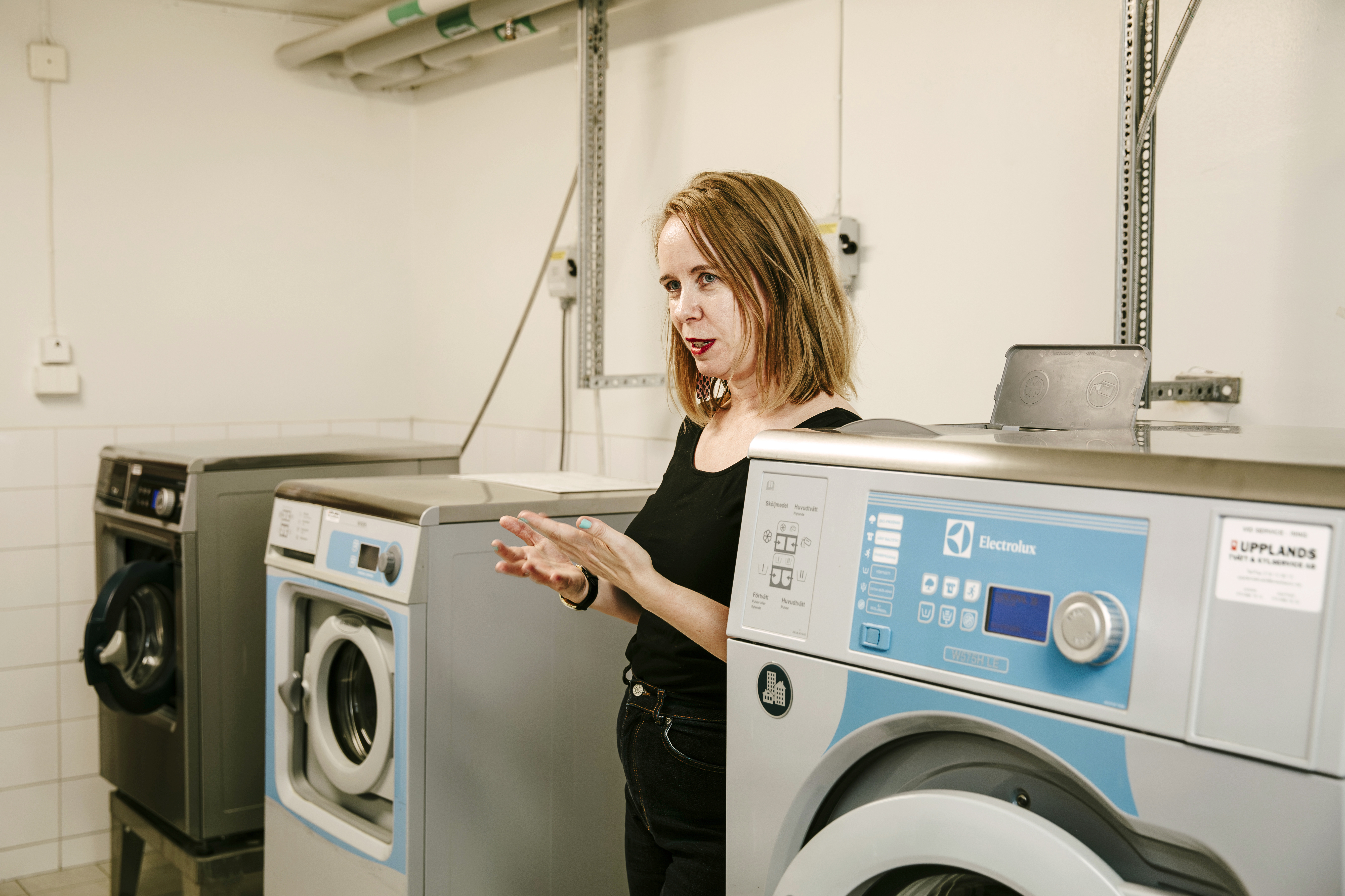Lena Sohl står mellan två tvättmaskiner