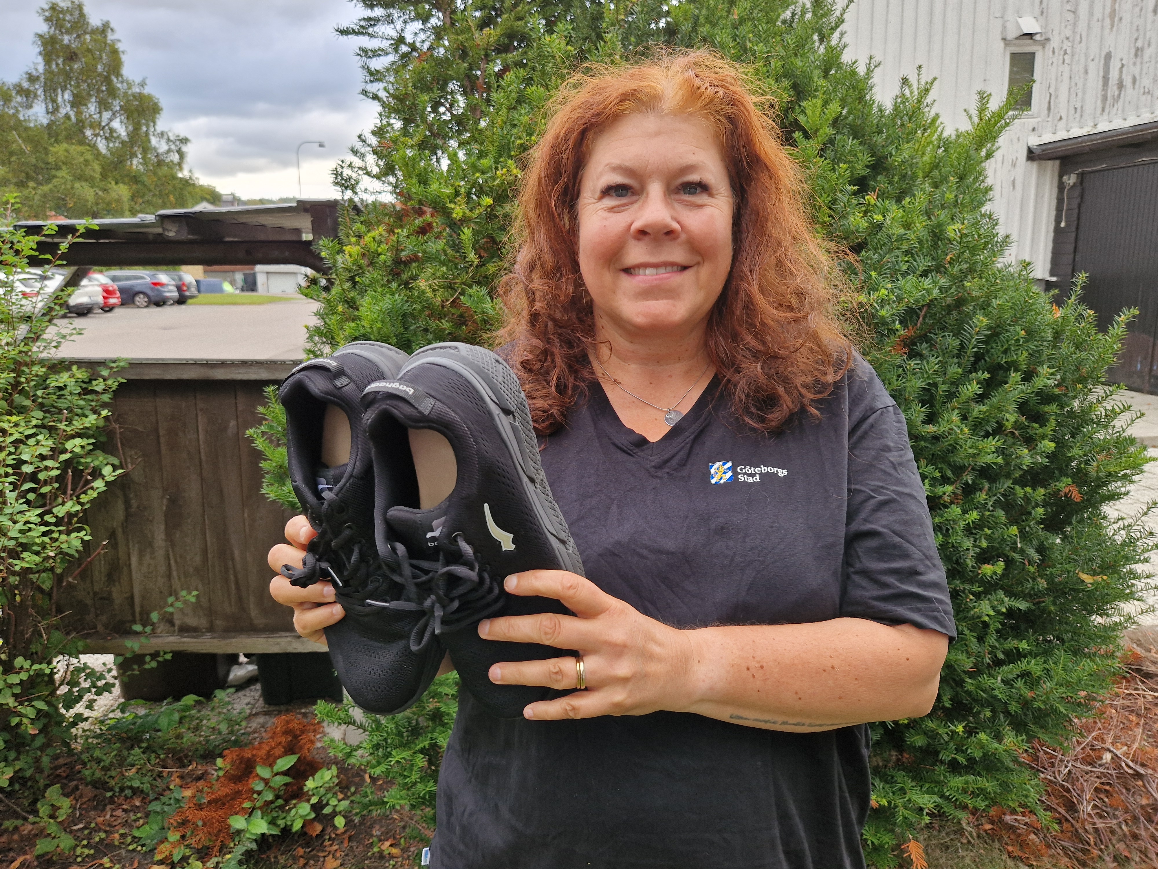 Sophie Ritzman hållandes ett par arbetsskor utomhus.