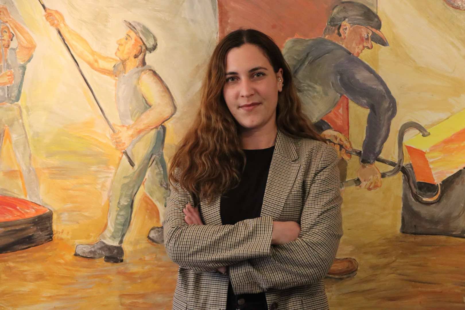 Alexandra Mentzas framför en stor målning,