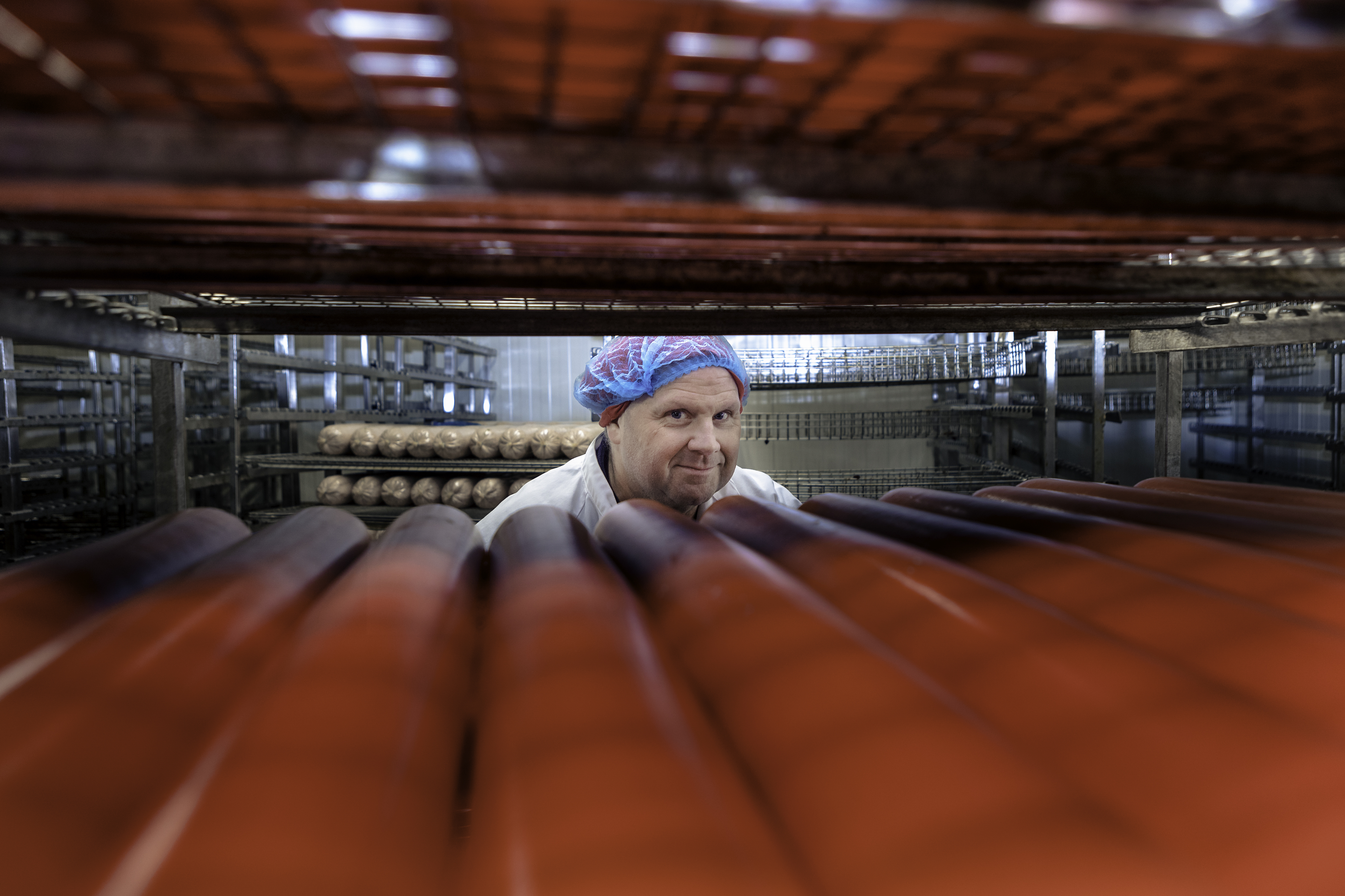 Micael Andersson bakom en hylla med röda rör