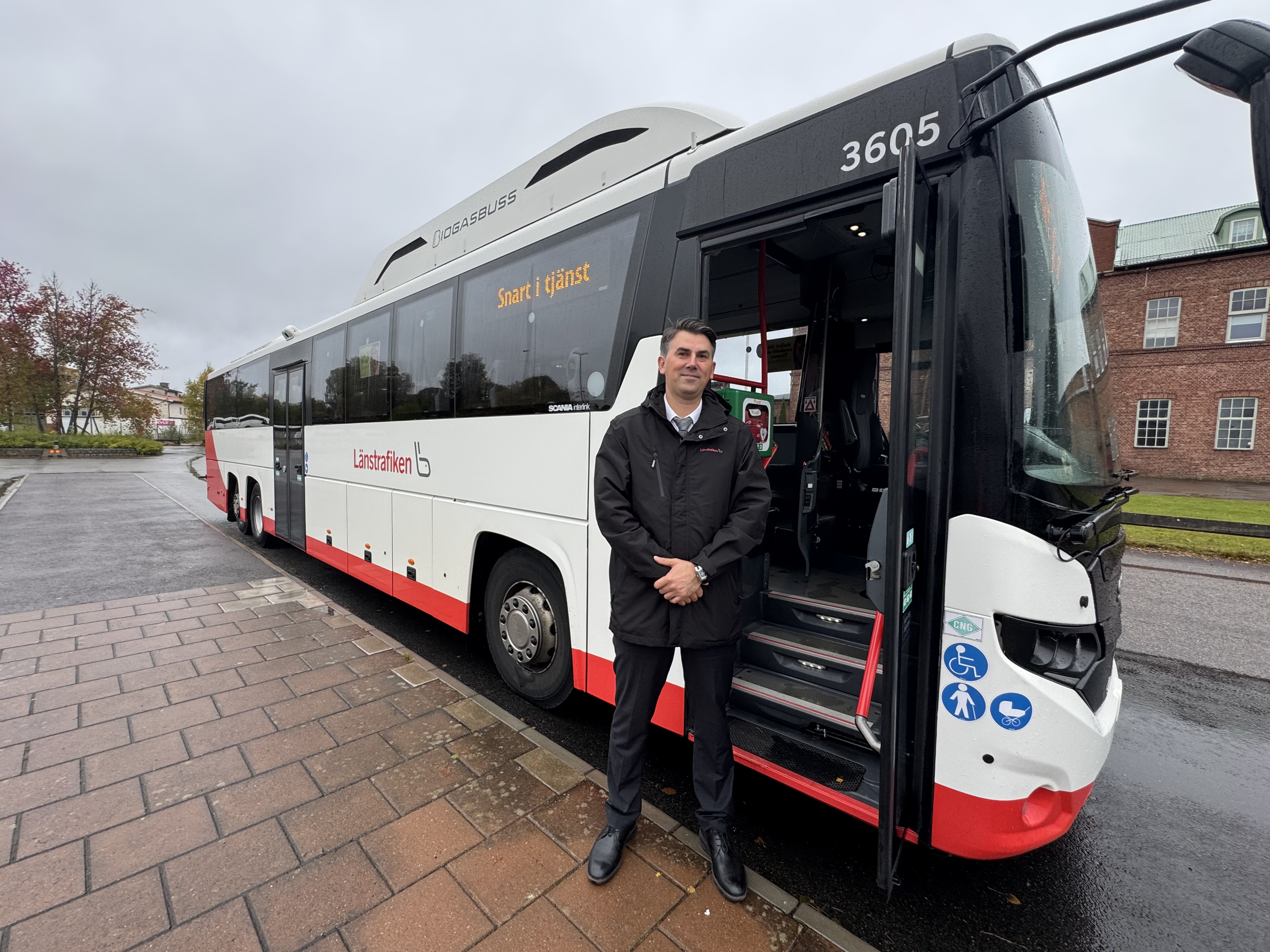 Henry Freeland står utanför en buss.